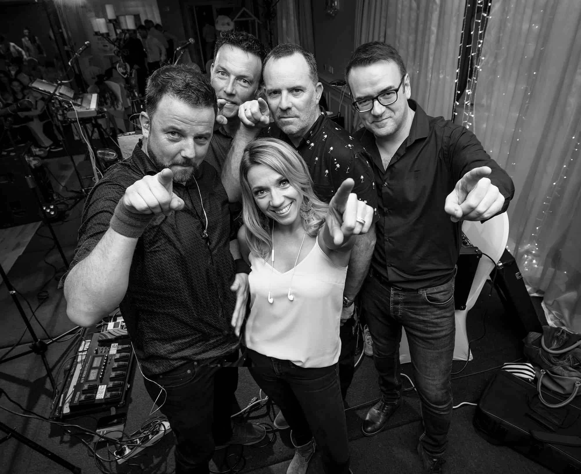 The whole band pointing at the camera