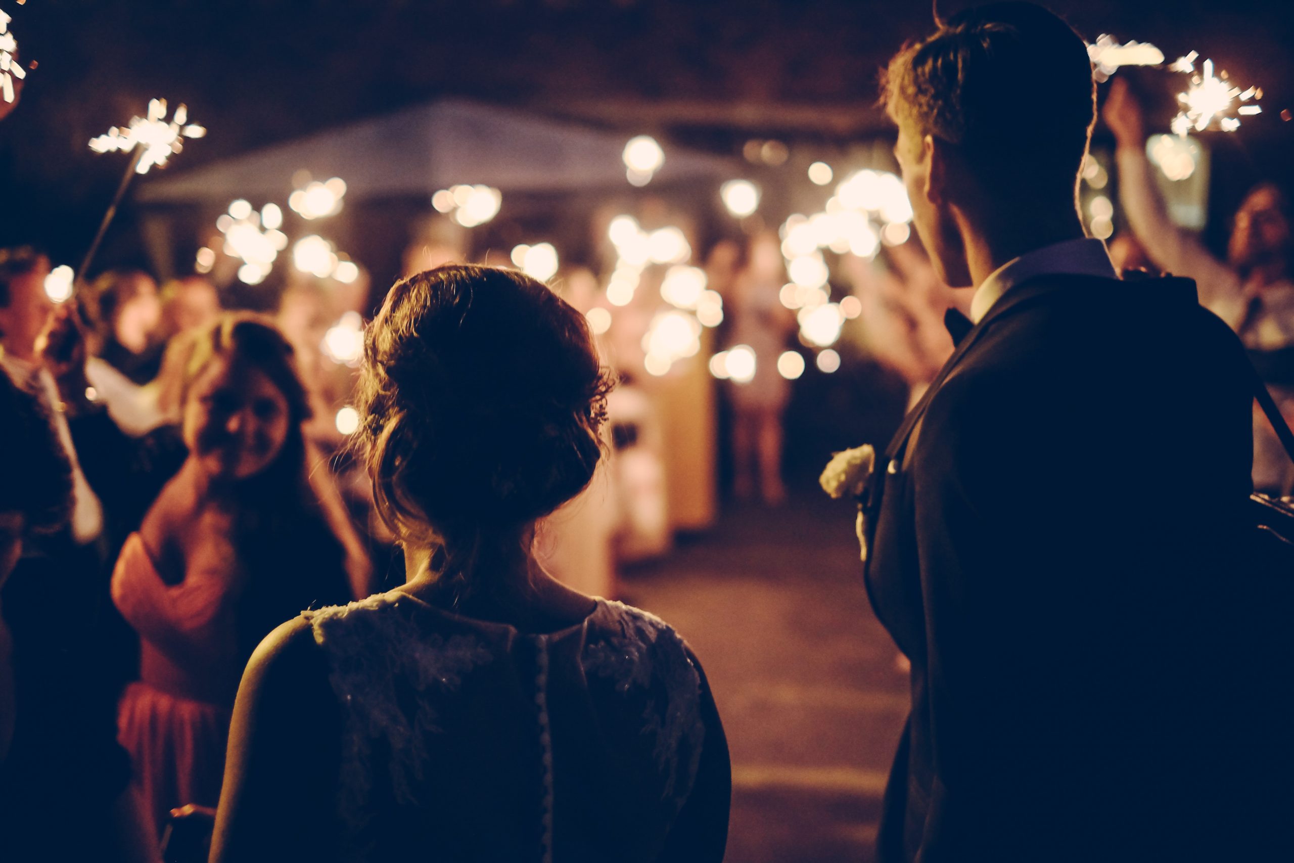 A couple approach the wedding reception with Sparklers